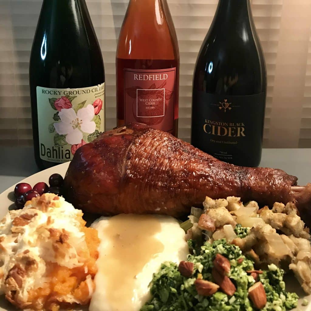 Thanksgiving drinks of cider with a plate of holiday food